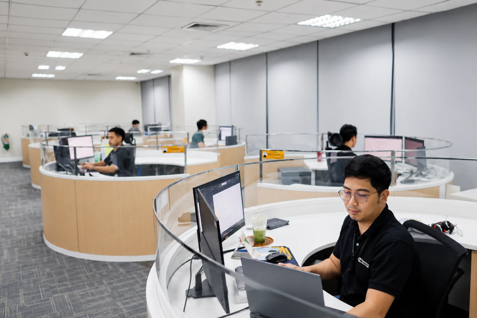 CF employee working at a curved workstation in the operations office